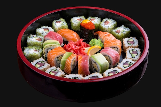 Sushi Set nigiri rolls and sashimi served in traditional Japan black Sushioke round plate On dark background