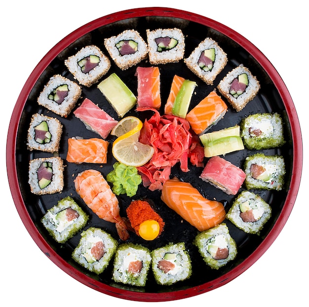 Sushi Set nigiri rolls and sashimi served in traditional Japan black Sushioke round plate On white background