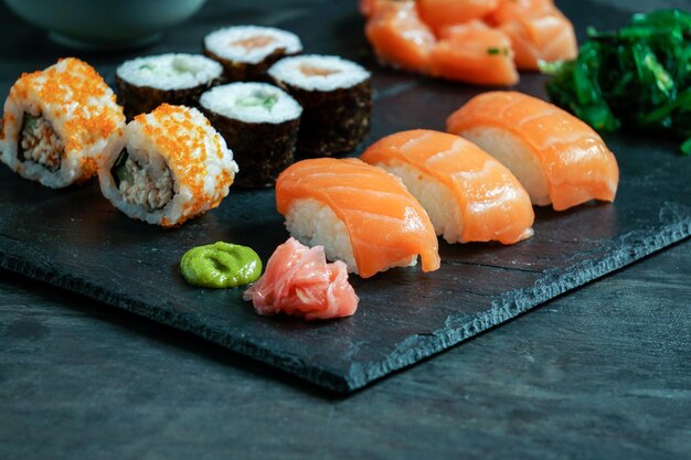 Sushi Set nigiri and sushi rolls on black stone slate on black background