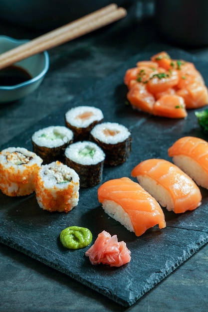 Sushi Set nigiri and sushi rolls on black stone slate on black background