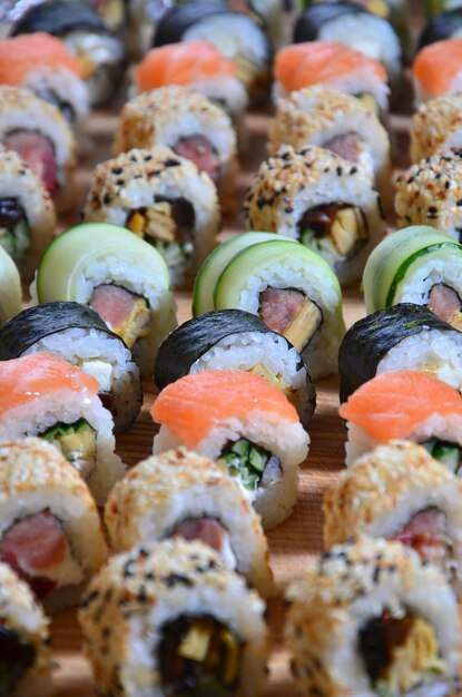 Sushi set of a number of rolls is located on a wooden cutting board