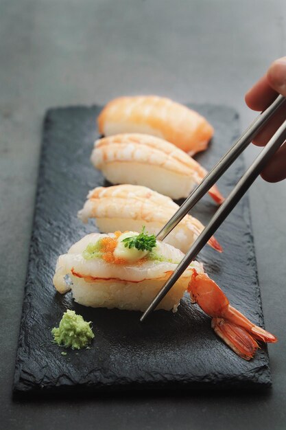 Sushi Set sashimi and sushi rolls served on stone plate over white  background with copy spaceJapan