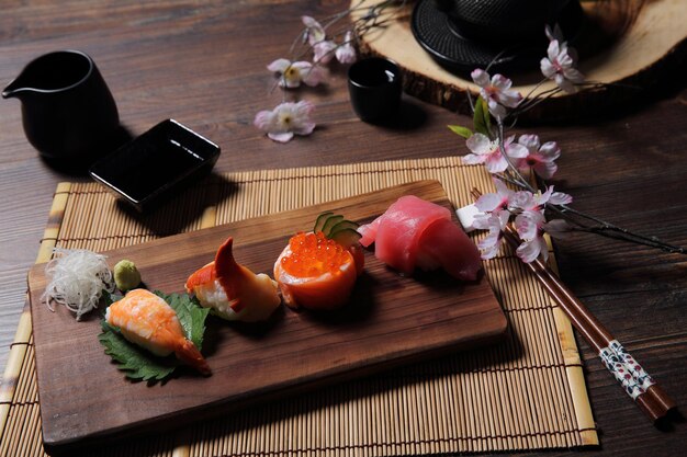 Sushi Set sashimi and sushi rolls with tea on wood background