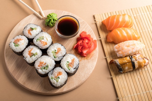 Sushi set uramaki and rolls served on bamboo mat and wooden board