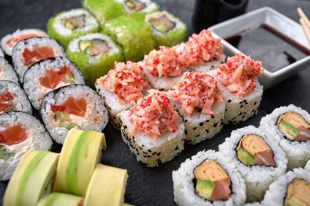 Sushi set van verschillende rollen, met kaviaar van vliegende vissen, tobiko, garnalen, paling, zalm, avocado, stokjes en sojasaus