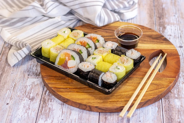 Sushi set with soy sauce and chopsticks in wooden