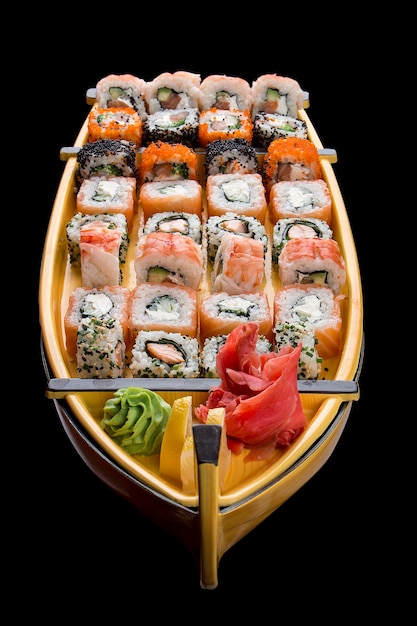 Sushi set in a wooden boat on a black background