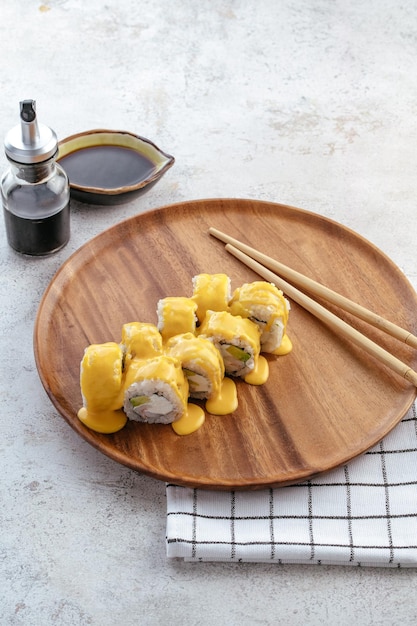 Sushi and soy sauce in a bowl and wooden chopsticks on a gray wooden table Japanese food Sushi Set Variety of rolls Menu