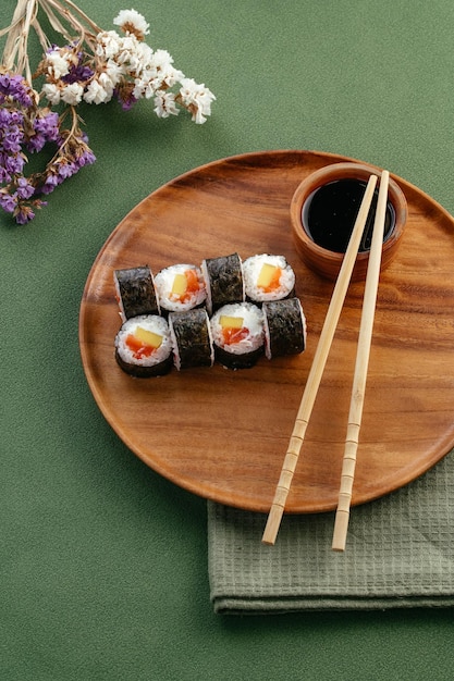 Sushi and soy sauce in a bowl and wooden chopsticks on a gray wooden table Japanese food Sushi Set