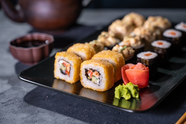 Sushi and sushi roll set on black stone table top view