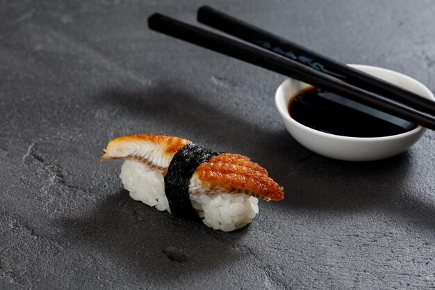 Sushi with chopsticks on grey stone background