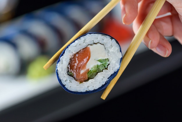 Sushi with chopsticks in hand.