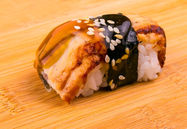 Sushi with fish on a wooden stand.