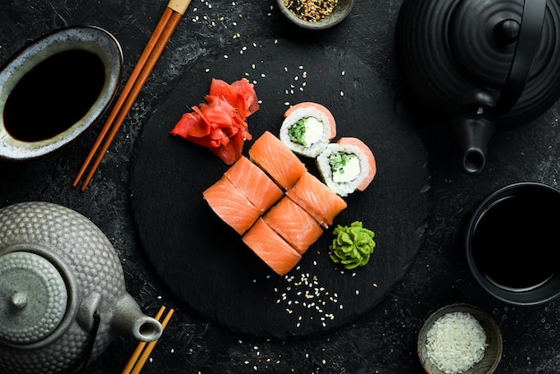 Sushi with salmon and Philadelphia cheese Traditional Japanese food On a black stone plate Top view