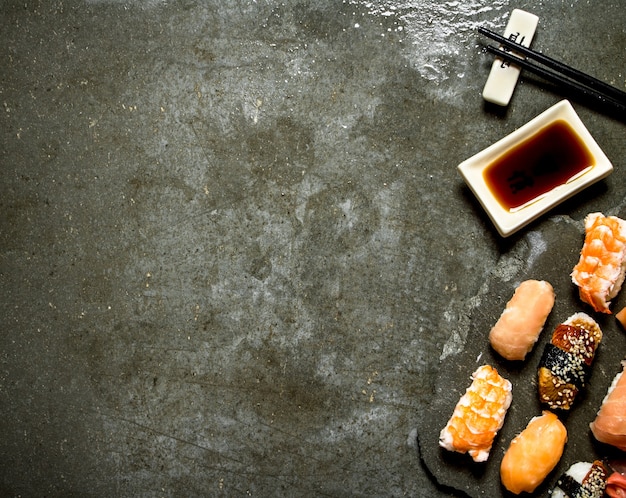 Sushi with soy sauce. On the stone table.