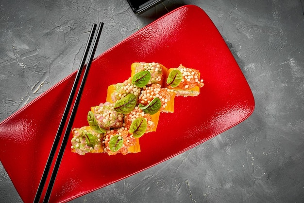 Sushibroodje met garnalenroomkaas en zalm in een rood bord