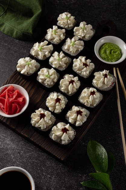 Sushibroodje met zalm, gerookte paling, avocado, roomkaas op een zwarte achtergrond