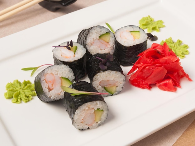 Sushibroodjes met garnalen en komkommer op een wit bord