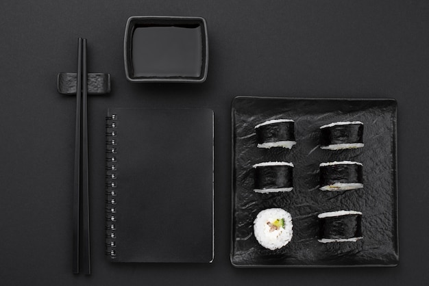 Sushibroodjes op plaat met notitieboekje en eetstokjes