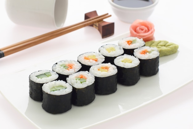 Sushimaki op een witte plaat wordt geplaatst die.