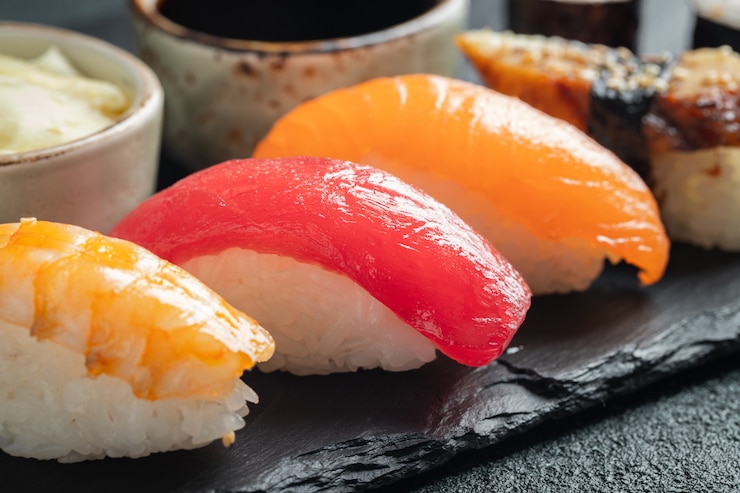 Foto sushireeks van zalm, tonijn en gerookte paling.