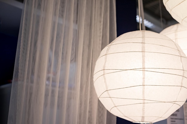 Подвесная белая лампа на размытом фоне современная люстра в скандинавском стилесовременный интерьер комнаты с красивой мебельюгостиная в современном дизайне