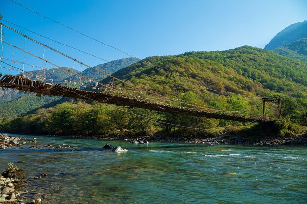 Ponte sospeso sul fiume di montagna bzyb. abkhazia, la strada per il lago ritsa.