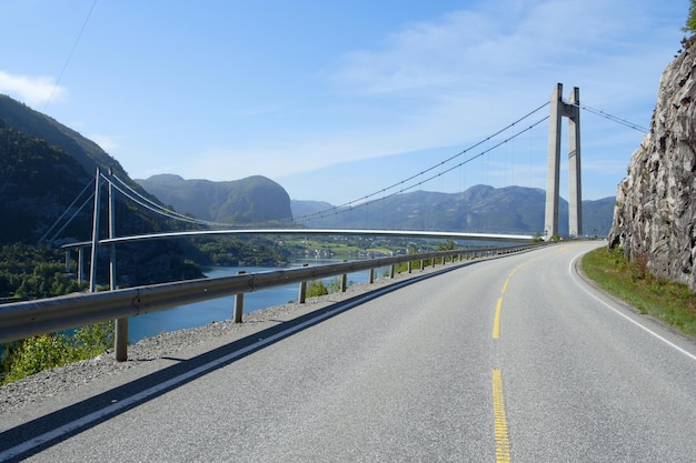 ノルウェーの山々の前景にある吊橋と道路