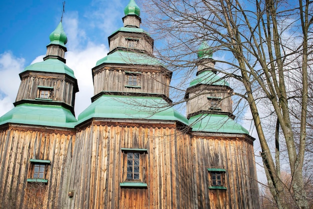 持続可能で木製の生態学的な快適な伝統的な国家民族スラブの本格的なスラブ教会の寺院で、田舎の村の田舎の風景、ウクライナのロシアの遺産