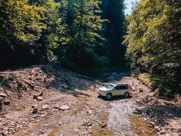 Suv car mountains creek on background copy space