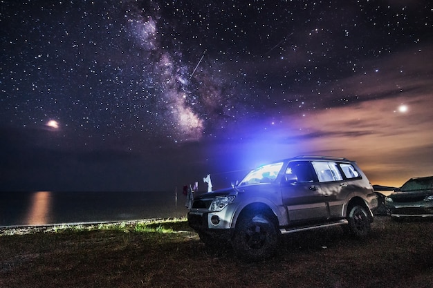 SUV en toeristische camping op het strand. Nachtschot