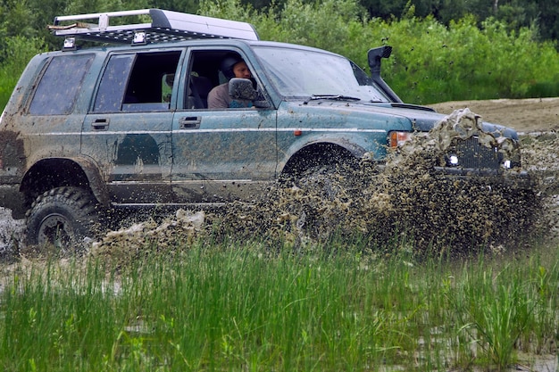 Photo suv or offroad vehicle crosses a river with splashes of dirty water