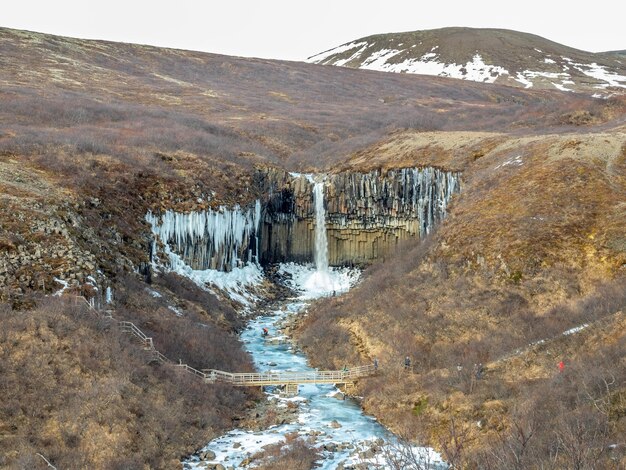 Svartifoss waterfall Iceland  in Vatnajokull national park in black larva sand plain water freeze