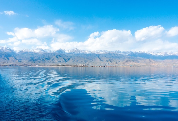 Sverny-oever van het IssykKul-meer in Kirgizië Uitzicht vanaf het schip naar de kust Blauw water van een bergmeer