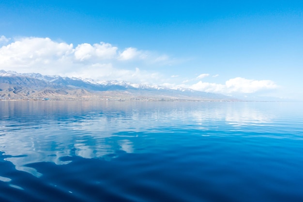 Sverny shore of Lake IssykKul Kyrgyzstan View from the ship to the shore Blue water of a mountain lake