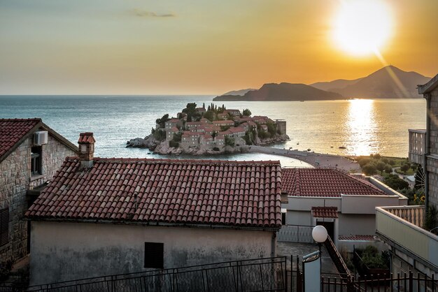 Sveti Stefan resort en rode daken bij zonsondergang in Montenegro