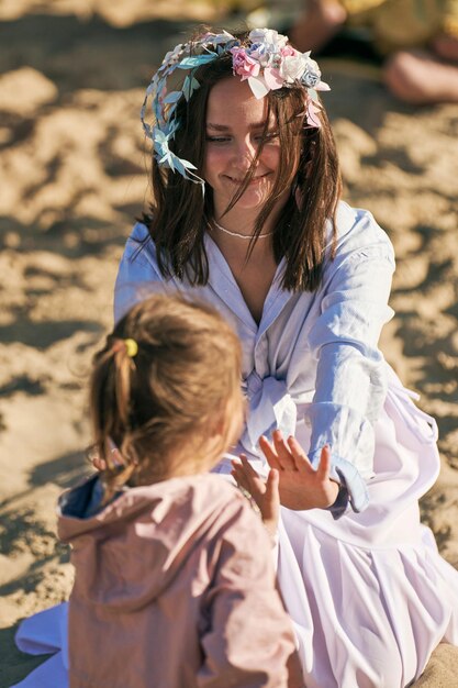 Svetlogorsk Russia 08152021  Hand clapping game of young woman actress with child at outdoor art performance Patty cake game of adult and kid on beach at daylight Outdoor children festival