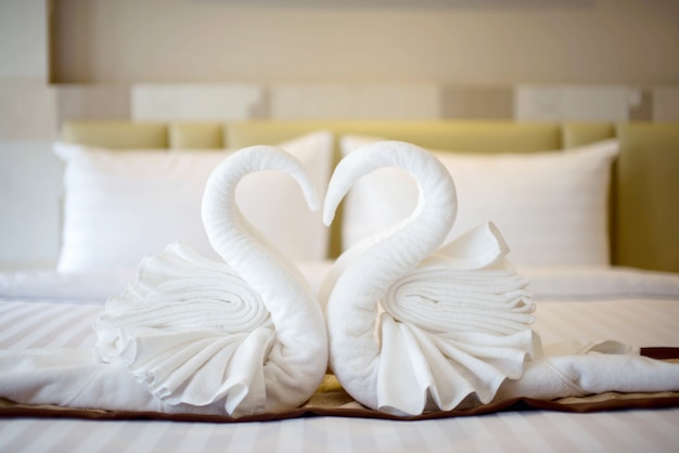 Swan towels on the bed in a hotel room