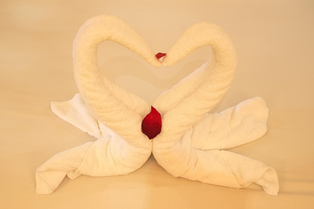 A swans made of towels on a bed in a hotel.