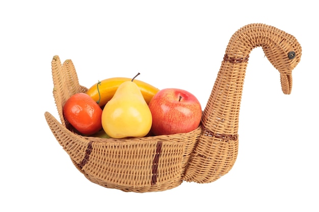 Swanshaped wicker basket with artificial fruits Isolated over white background Closeup