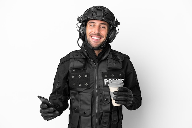 SWAT blanke man geïsoleerd op een witte achtergrond met koffie om mee te nemen en een mobiel