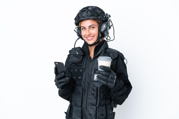 SWAT-kaukasische vrouw geïsoleerd op een witte achtergrond met koffie om mee te nemen en een mobiel
