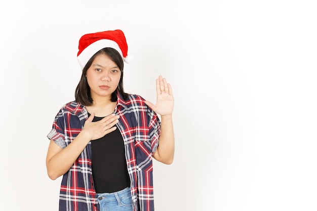 Swearing Gesture of Beautiful Asian Woman Wearing Red Plaid Shirt and Santa Hat Isolated On White Ba