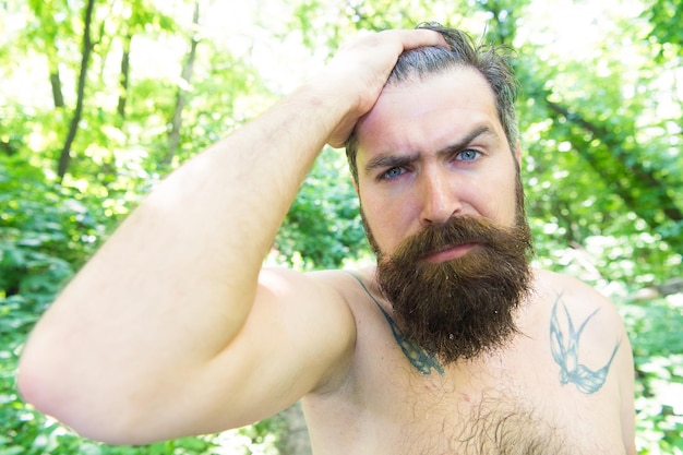 Photo sweating and body odor care. perspiring hipster touching his wet hair. bearded man experiencing sweating on hot day. mens skin care routine for summer. good skin care. taking care for his skin.