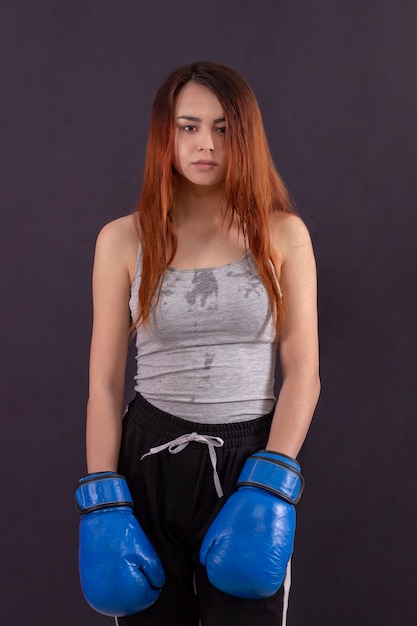 Photo sweaty boxer girl with boxing gloves standing