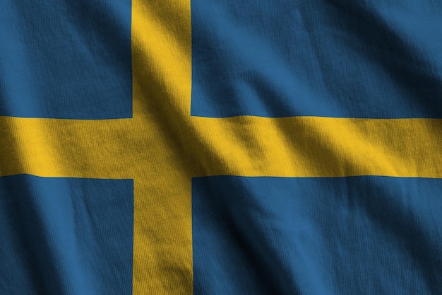 Photo sweden flag with big folds waving close up under the studio light indoors the official symbols and colors in banner