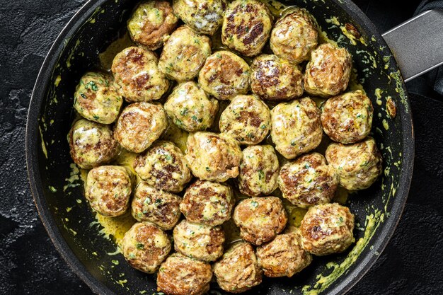 Swedish Meatballs with Cream Sauce in a skillet Black background Top view