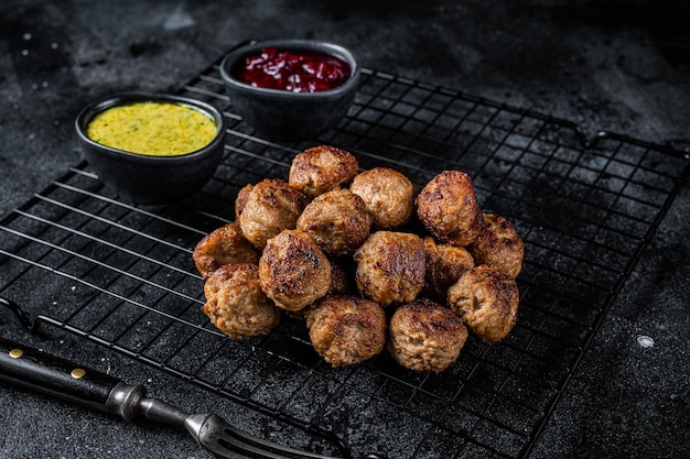 Swedish meatballs with lingonberries and gravy sauce Black background Top view