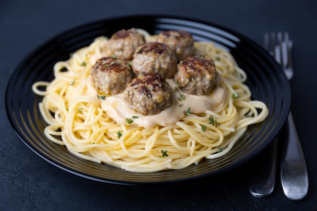 Swedish noisettes fricandel with spaghetti and Brune Sos creamy sauce Traditional meatballs with garnish Selective focus closeup