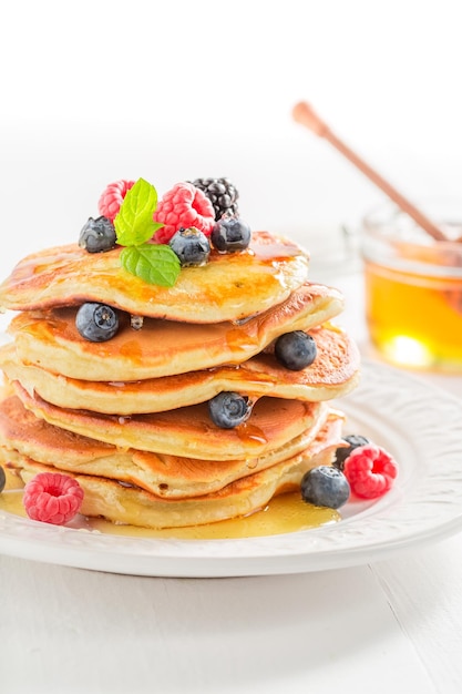 Sweet american pancakes with maple syrup and berries